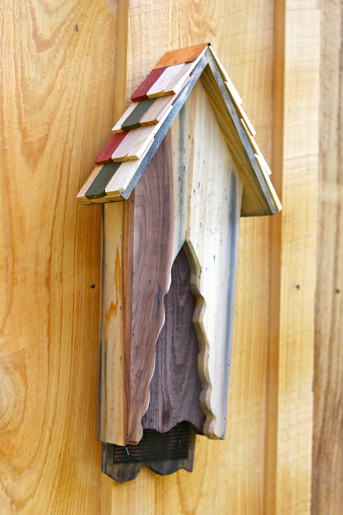 Vintage bat house with wooden slat design and roofed top