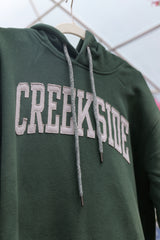 Cream Creekside Hoodie folded on a plain surface